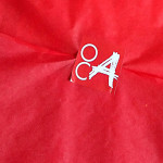 Red tissue paper with the white on red OCA logo in the middle