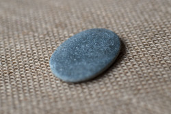 A smooth grey pebble on hessian